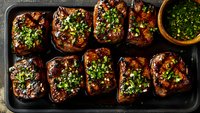 Grilled eggplant slices with herbs and spices on baking tray, healthy Mediterranean vegetarian cuisine for cooking blogs and recipe websites.