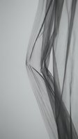 Abstract monochrome flowing fabric with elegant curves and soft shadows creating minimalist textile art for modern interior design and fashion concepts.