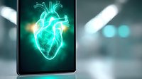 Glowing turquoise anatomical heart hologram displayed on tablet screen with blurred medical background, modern healthcare technology visualization.