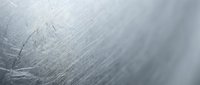 Brushed metal surface with fine scratches and industrial texture showing metallic gray finish with shallow depth of field for modern design projects.
