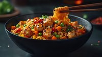 Asian noodles with shrimp, vegetables and sauce in black bowl, chopsticks holding noodles above dish, dark moody food photography background.