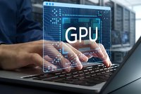 Professional developer working on laptop with holographic GPU processor display and circuit board graphics for computing technology projects.