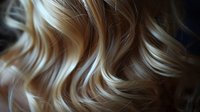 Close-up of wavy blonde hair with highlights and lowlights showing natural texture and shine. Perfect for beauty, haircare, and salon advertising.