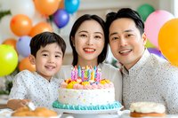 Happy Asian family celebrating birthday with colorful cake and balloons background, joyful moment at home party, genuine emotions and festive atmosphere.
