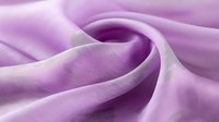 Soft purple silk fabric with elegant flowing curves and gentle folds creating luxurious textile waves for fashion design and decorative projects.