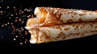 Freshly baked cream horn pastries with caramel drizzle and sugar sprinkles on dark background, close-up view showing flaky texture and sweet filling.