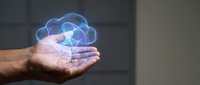 Male hands holding glowing holographic cloud computing icon with colorful geometric elements for technology and data storage concepts.