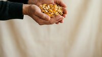 Farmer's hands holding golden corn kernels against neutral background, representing harvest, agriculture, and grain production for farming and food industry concepts.