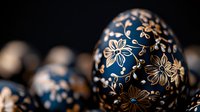 Decorative Easter egg painted in deep blue with delicate gold floral pattern and ornate details, traditional folk art style on dark background with soft bokeh effect.