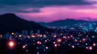 Glowing lights scattered across mountainous landscape at dusk with purple and pink sky, creating magical evening cityscape atmosphere with bokeh effect and soft focus.