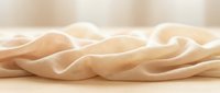 Twisted beige fabric or textile with soft folds and waves, isolated on neutral background, suitable for design projects and creative compositions.