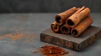 Aromatic cinnamon sticks arranged on rustic wooden board with ground powder scattered on dark textured surface, moody food photography for culinary designs.
