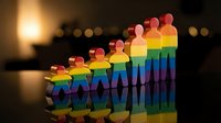 Colorful rainbow paper cutout figures holding hands in unity, representing diversity, inclusion and LGBTQ pride community support with warm bokeh background.