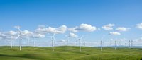 Wind turbines generating clean renewable energy across green rolling hills under blue sky with white clouds for sustainable power production.