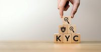 Hand placing wooden cube with magnifying glass icon above KYC blocks with security symbols for compliance verification and customer identification processes.