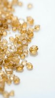 Golden yellow citrine gemstones scattered on white background, natural rough cut crystals for jewelry making and healing stone collection.