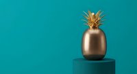 Golden pineapple sculpture on turquoise pedestal against teal background. Modern minimalist home decor accent piece for contemporary interior design styling.