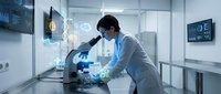 Asian male scientist in white lab coat examining samples under microscope in modern laboratory with digital displays and advanced equipment.