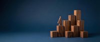 Wooden blocks stacked in ascending formation against dark blue background, representing business growth, success, and career advancement for corporate presentations.