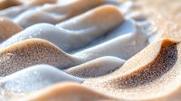 Abstract sandy beach landscape with smooth undulating dunes and golden textures, creating a serene natural pattern for backgrounds or environmental concepts.