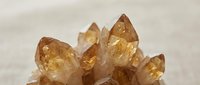Cluster of golden brown citrine quartz crystals with natural terminations and translucent facets on neutral background for mineral collection and geology education.