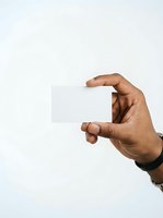Hand holding blank white card isolated on white background, suitable for business card mockups, promotional materials, and branding presentations.