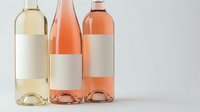 Three elegant wine bottles with blank labels showcasing white, rosé, and orange wines on clean background for branding and marketing projects.