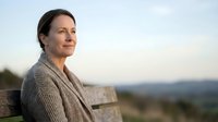 Mature Caucasian woman in cozy sweater enjoying peaceful sunset moment outdoors with serene expression and natural lighting for wellness lifestyle content.