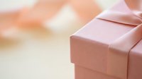 Pink gift box with satin ribbon on soft blurred background for celebrations, holidays, birthdays, anniversaries, and special occasions.