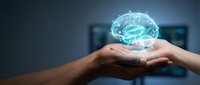 Glowing digital brain hologram floating above cupped hands representing artificial intelligence, machine learning, and innovative technology solutions.
