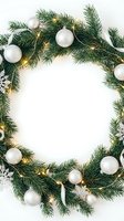 Christmas wreath with silver ornaments and warm lights on white background creating festive frame for holiday greeting cards and seasonal decorations.