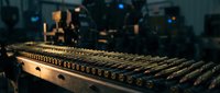 Professional audio mixing console with illuminated controls in modern recording studio environment for music production and sound engineering projects.