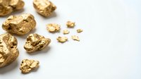 Shiny golden nuggets and flakes scattered on white background for mining, investment and precious metal concepts.