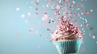 Sweet vanilla cupcake with pink frosting and flying sprinkles against mint green background, captured in dynamic motion with soft focus and dreamy atmosphere.
