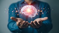 Professional presenting glowing brain hologram with neural connections and light effects above cupped hands for artificial intelligence and neuroscience concepts.
