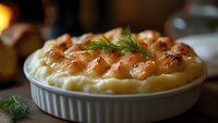 Golden baked potato gratin with crispy top and fresh dill garnish in white ceramic dish on rustic kitchen table for comfort food recipes and cooking blogs.