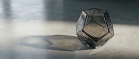 Geometric glass polyhedron casting dramatic shadow on concrete surface, modern minimalist design element for contemporary art and architectural visualization projects.