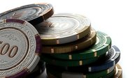 Stacked casino poker chips in various colors with detailed metallic edges and denomination markings, suitable for gambling, gaming, and entertainment design projects.
