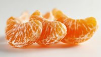 Fresh peeled tangerine segments arranged in a row on white background, showcasing juicy orange citrus fruit texture for food photography.