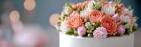 Elegant wedding cake topped with fresh pink roses, white chrysanthemums and greenery against soft bokeh background for celebrations and special occasions.