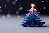 Handcrafted paper Christmas tree in vibrant purple and blue gradient colors with glowing star topper against dark background with bokeh lights and copy space.