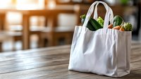 White reusable shopping bag filled with fresh groceries and vegetables on wooden table, eco-friendly lifestyle concept for sustainable shopping and zero waste.