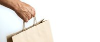 Senior man hand holding brown paper shopping bag isolated on white background for retail and consumer concepts.