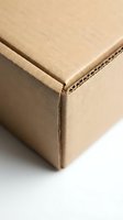 Brown corrugated cardboard box corner detail showing layered construction and packaging material texture for shipping and storage solutions.