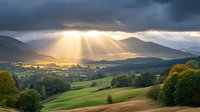 Dramatic sunbeams pierce through storm clouds over rolling hills and green meadows, creating golden light rays across rural mountain landscape at sunset. Perfect for wall art.