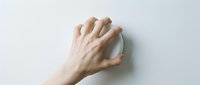 Hand holding white computer mouse on clean white background isolated for technology and office design projects.