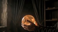 Young male hand holding glowing crystal ball in dark room with curtains, fortune telling and mystical divination concept for spirituality and magic themes.