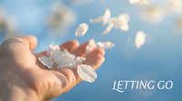 Young woman releasing white flower petals from cupped hands against blue sky background symbolizing freedom, letting go, mindfulness and new beginnings.
