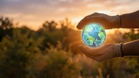 Hands holding glowing recycling symbol against sunset landscape, representing environmental sustainability, green energy, and eco-friendly conservation efforts.