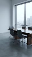 Modern conference room with wooden table and black chairs overlooking city skyline through large windows for corporate meetings and business presentations.